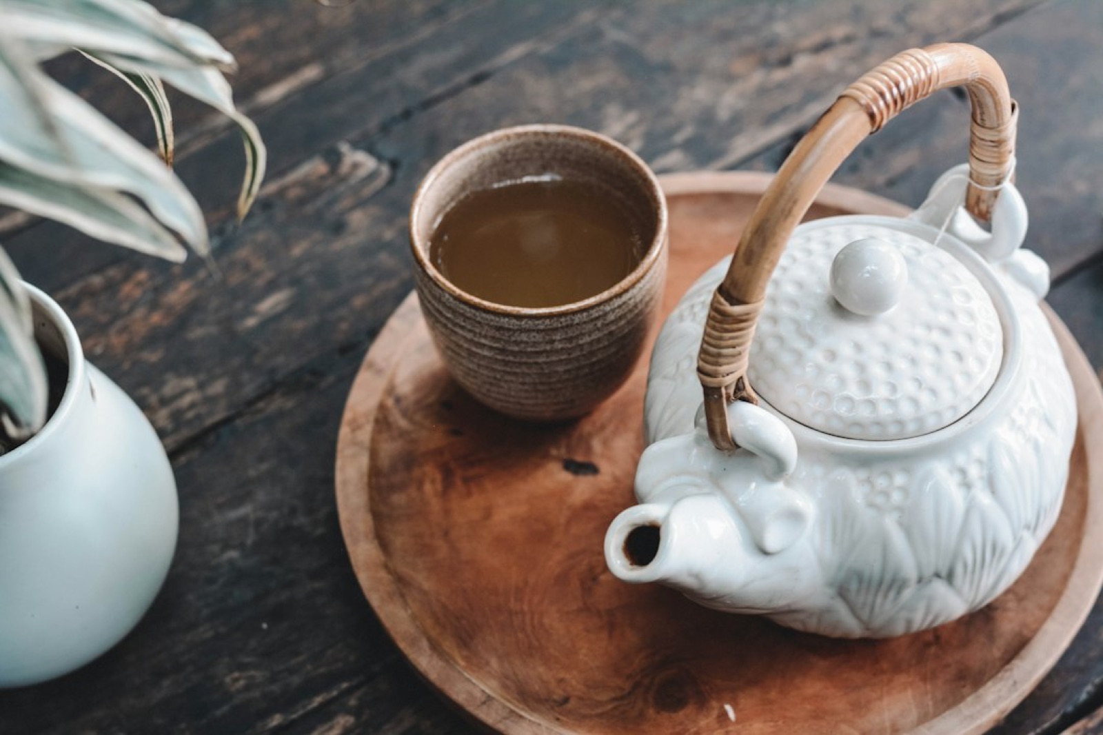 A teapot and cup on a wooden tray